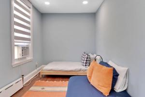 費城的住宿－Stylish Rowhome-Fishtown-Near Shops，一间卧室设有蓝色的沙发和窗户。