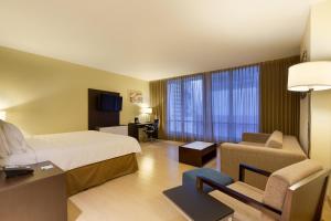 Habitación de hotel con cama, sofá y silla en Holiday Inn Panama Distrito Financiero, an IHG Hotel, en Panamá