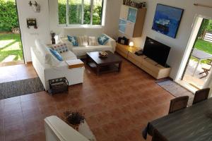 a living room with a couch and a tv at Villa SA CALMA ESVENTADA - Relax y confort a sólo 5 minutos de la playa in Es Mercadal