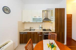 een kleine keuken met een tafel en een wastafel bij Sea Organ Apartment Zadar in Zadar