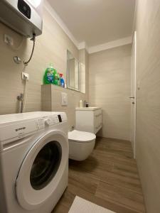 uma casa de banho com uma máquina de lavar roupa e um WC em Apartment Lida em Podstrana