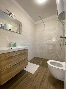 a white bathroom with a sink and a toilet at Apartment Lida in Podstrana +8 photos