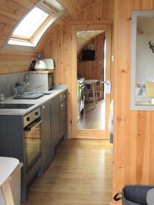 a kitchen with wooden walls and a skylight at Harlosh Hideaways - Stargazer Pod in Harlosh
