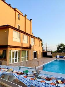 una mesa frente a una casa y una piscina en Byala Residence Apartments, en Byala