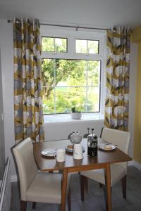 un tavolo da pranzo con sedie e una finestra di Mullarts Church -The Glendun Apartment a Knocknacarry