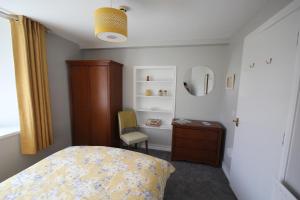 a bedroom with a bed and a dresser and a mirror at Mullarts Church -The Glendun Apartment in Knocknacarry