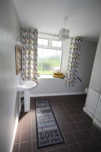 a bathroom with a sink and a window with a sink at Mullarts Church -The Glendun Apartment in Knocknacarry