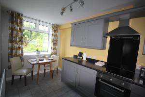 a kitchen with a table and a stove top oven at Mullarts Church -The Glendun Apartment in Knocknacarry