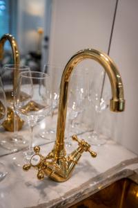 a gold faucet on a counter with wine glasses at Washington Street Quarters in Lewisburg