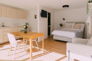 een klein appartement met een slaapkamer, een tafel en een bed bij Bacherlhaus in Traunkirchen