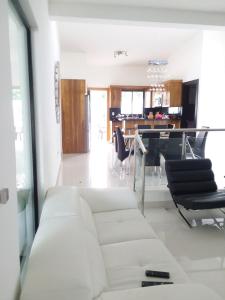 a living room with a white couch and a dining room at White House Mansion in San Felipe de Puerto Plata