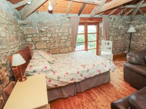 a bedroom with a bed and a stone wall at The Granary in Morpeth