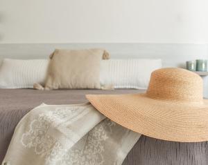 a straw hat sitting on top of a bed at B&B Oplonti Resort in Torre Annunziata