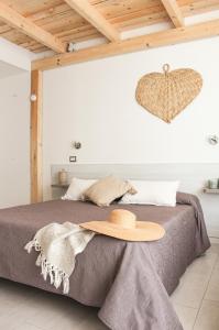 a hat is sitting on a bed in a bedroom at B&B Oplonti Resort in Torre Annunziata