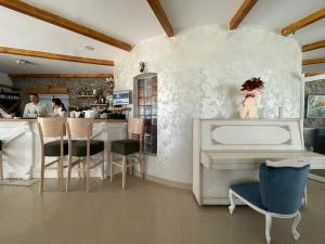 a restaurant with a white piano and a counter at Garni hotel Oblačinsko jezero in Oblačina