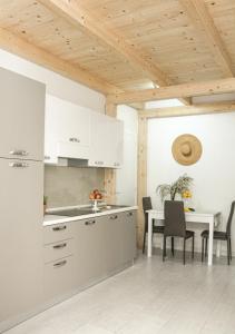 a kitchen with white cabinets and a table with chairs at B&B Oplonti Resort in Torre Annunziata