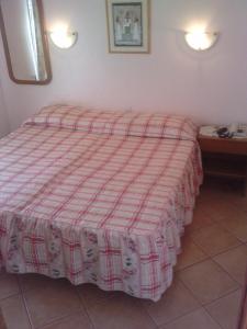 a bedroom with a bed with a red and white blanket at Residencial Nosso Paraiso in Quarteira