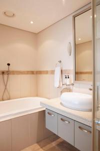Baño blanco con bañera y lavamanos en 504 Kylemore, en Ciudad del Cabo
