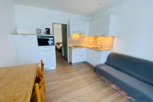 a kitchen with a table and a couch in a room at Appartement 2 pièces plage de Nauzan in Saint-Palais-sur-Mer +2 photos