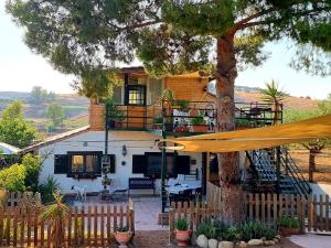 een huis met een boom en een gele paraplu bij Sunset Valley Village in Motta SantʼAnastasia
