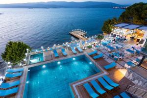 een uitzicht over het zwembad met uitzicht op het water bij Güllük Yalı Boutique Otel in Gulluk