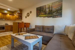 ein Wohnzimmer mit einem Sofa und einem Tisch in der Unterkunft Apartman Lena in Zlatibor