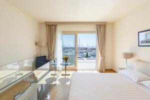 a hotel room with a bed and a glass table at Marina di Scarlino Resort in Puntone di Scarlino