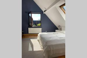a bedroom with a white bed and a window at Fresh Cosy Flat In Zakopane Center in Zakopane