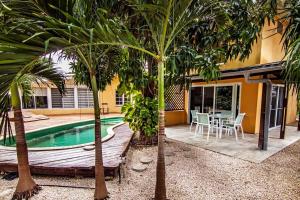 a house with a pool and a table and trees at Appartement met zwembad en prachtige tuin in Willemstad