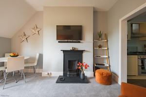 sala de estar con chimenea y TV en Pitch Perfect by Bloom Stays, en Canterbury