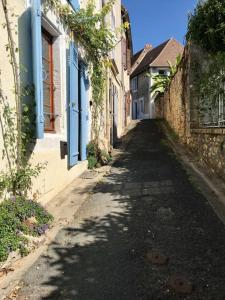 an empty alley with buildings and a street with trees at Chez Claire in Excideuil