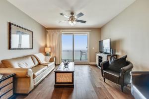 a living room with a couch and a television at Sterling Breeze #1702 by Book That Condo in Panama City Beach