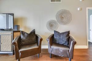 two leather chairs in a living room with a tv at Sterling Breeze #1702 by Book That Condo in Panama City Beach