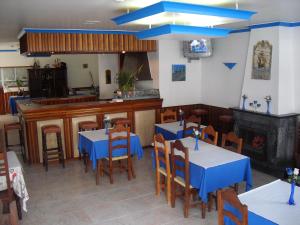 a restaurant with blue tables and chairs and a fireplace at Residencial Nosso Paraiso in Quarteira