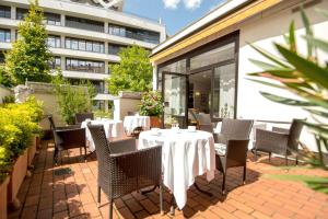 a patio with tables and chairs and a building at domus Hotel in Munich