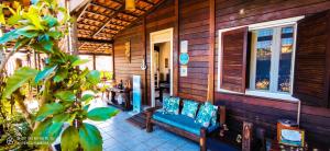 un porche de una casa de madera con un sofá azul en Pousada Alamoa, en Fernando de Noronha
