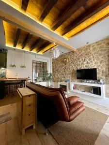 a living room with a leather couch and a television at LA CASITA in Zamora