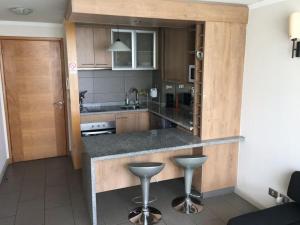 a kitchen with a counter and two bar stools at Reñaca Park in Viña del Mar