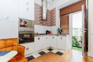 a kitchen with white cabinets and a large window at LaFlats Tverskaya 15 Strong in Moscow