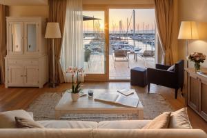 a living room with a couch and a view of a marina at Marina di Scarlino Resort in Puntone di Scarlino