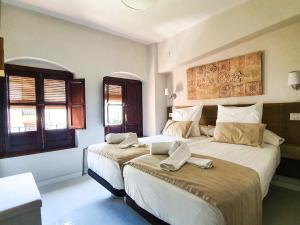 コルドバにあるCasa con Terraza San Fernandoのベッドルーム1室(ベッド2台、窓2つ付)