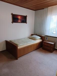 a bedroom with a bed and a picture on the wall at Ferienhaus Birkenallee in Papenburg