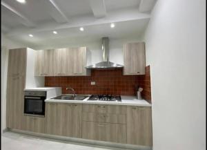 a kitchen with wooden cabinets and a stove top oven at Zaras 11 in Lacco Ameno