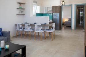 eine Küche und ein Wohnzimmer mit einem Tisch und Stühlen in der Unterkunft Kalypso Apartment Ierapetra in Ierápetra