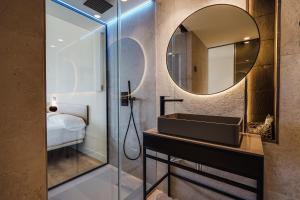 a bathroom with a sink and a mirror at Hotel Brisamar Suites in Comarruga