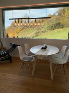 una mesa y sillas blancas en una habitación con ventana en Blickfang, en Lochau