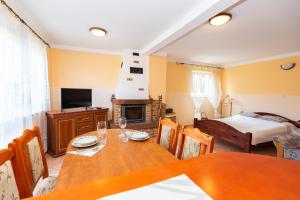 a living room with a dining table and a bedroom at Dom o dwóch niezależnych kondygnacjach in Jastrzębia Góra