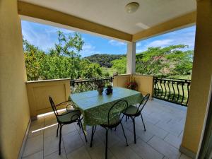 a patio with a table and chairs on a balcony at Bougenville in Kampor
