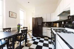 a kitchen with a black and white checkered floor at 4 Bedroom NYC Apartment in New York