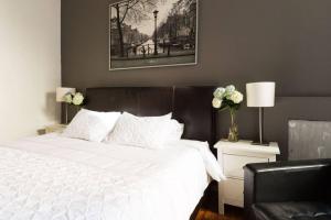 a bedroom with a white bed with a black headboard at 4 Bedroom NYC Apartment in New York